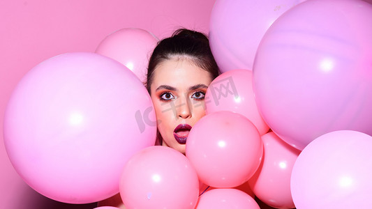 气球党在粉红色的工作室背景。复古的女孩与时尚的化妆和头发。生日装饰和庆祝。女孩梦想在强力粉彩趋势。时尚女人与许多粉红色的空气气球.