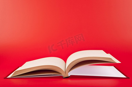 商务红色背景摄影照片_红色背景上的书
