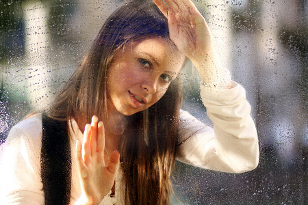 雨后玻璃摄影照片_雨后窗户附近的年轻女子