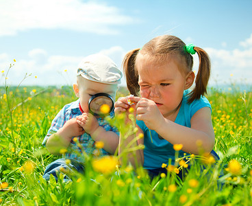 采草摄影照片_孩子们正在玩绿色草地上