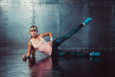 athlete woman exercising warming up and stretching lying on her side the floor with  leg raised concept training fitness, sport, healthy lifestyle.