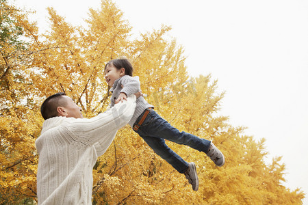 父亲和儿子在秋天玩一个公园