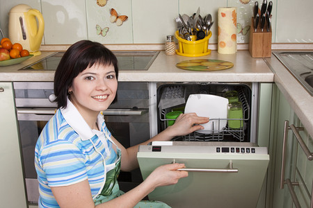 深色商务摄影照片_深色头发的女人清洗厨房
