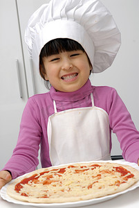 章子摄影照片_持有 pizza.little 女孩与持有一个披萨厨师帽的小女孩.
