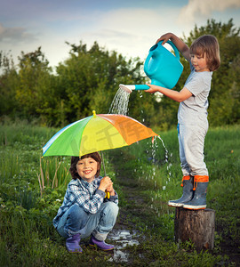 雨天自然摄影照片_两个兄弟在户外雨天玩耍