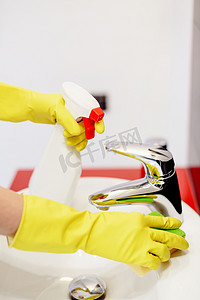 女手与清洁用海绵轻轻的黄色橡胶手套.