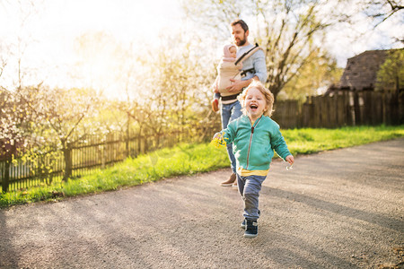 一个父亲与他的蹒跚学步的孩子在外面的春天散步.