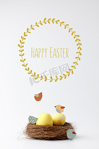 黄色彩绘复活节彩蛋在装饰巢与绘制的鸟类和快乐的复活节字母白色