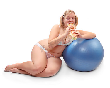 超重的女人坐在健身球吃大的三明治的张有趣的图片.
