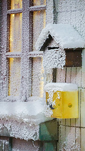 下雪圣诞摄影照片_冬天雪景小屋窗户信箱下雪摄影图配图