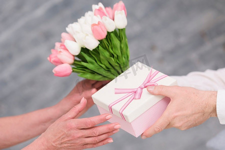 男人的手给予生日礼物郁金香鲜花花束他的妻子