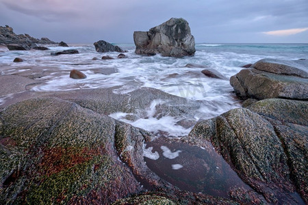 福塔摄影照片_冬日日落时分，挪威海峡湾海滩上的岩石。乌塔克列夫海滩，罗福滕群岛，挪威。挪威峡湾海滩