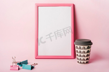 粉色背景摄影照片_白色相框，粉色边框，粉色背景下的一次性咖啡杯