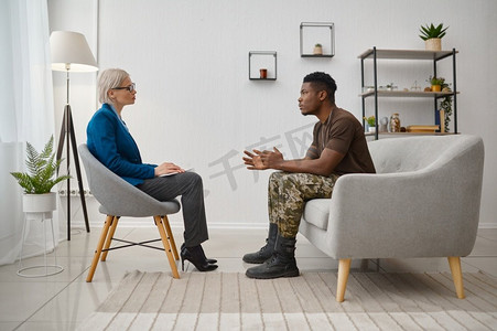 坐在心理学家面前的军人病人。创伤后应激障碍心理创伤治疗。坐在心理医生面前的军人男性患者