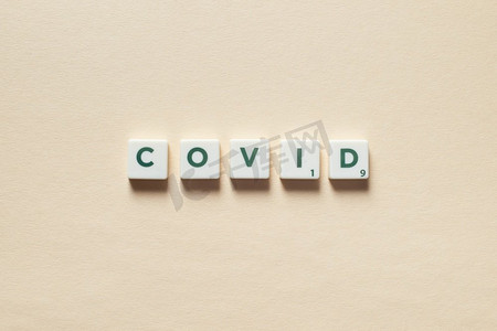 新冠病毒词形成的拼字瓷砖在米色背景。冠状病毒感染与医疗理念新型冠状病毒由拼砖形成。