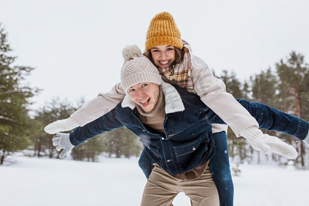 免费圣诞摄影照片_人，季节，爱和休闲概念—快乐的夫妇有乐趣在冬季公园。快乐的夫妇有乐趣在冬季公园