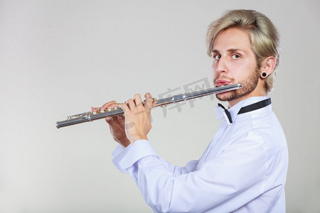 长笛音乐演奏专业男长笛演奏家。年轻优雅时尚的男子与仪器。他的长笛演奏家