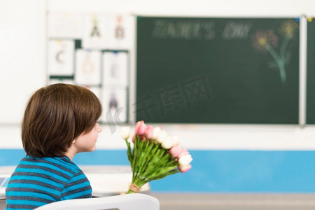 卡通老师卡通学生摄影照片_孩子拿着花束他的老师
