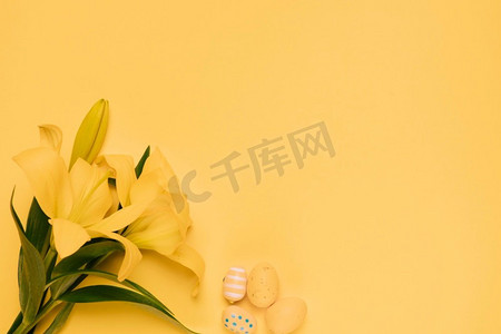 美丽的黄色百合花与复活节彩蛋黄色背景