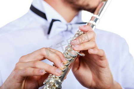 长笛音乐会摄影照片_年轻人吹笛子的手。男性长笛演奏家演奏者手持乐器，关闭。手的年轻人吹长笛