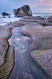 福塔摄影照片_冬日日落时分，挪威海峡湾海滩上的岩石。乌塔克列夫海滩，罗福滕群岛，挪威。挪威峡湾海滩