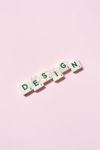 设计词形成的拼字块在粉红色背景，静物与复制空间在粉红色背景的拼字游戏块形成的设计。