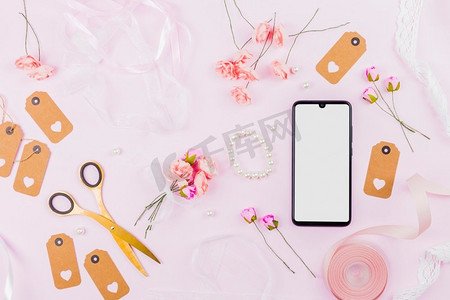 白色屏幕显示移动电话丝带玫瑰标签珍珠粉红色背景