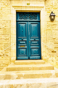 石屋外立面有老木制的深蓝色大门。法国的建筑..石头房子，木制的蓝色门。