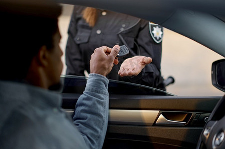 特写镜头汽车司机给女警察钥匙。车祸或超速的后果。特写镜头汽车司机给钥匙给女警察