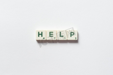 帮助词形成的拼字块在白色背景。援助和应急概念由拼字游戏块组成的帮助。
