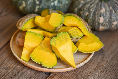 新鲜的亚洲泰国南瓜来自花园，用于烹饪或甜点，切碎的南瓜，绿色的南瓜食物在木质切菜板的背景下