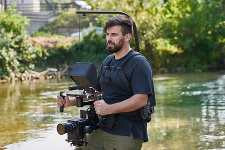 一名专业摄影师在被美丽的大自然环绕的水中拍摄，
