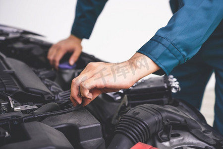 专业技工手提供汽车维修和保养服务在汽车修理厂。汽车服务的经营理念。