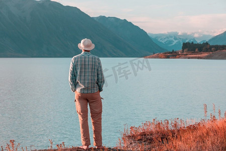 享受旅行摄影照片_一个人在平静的湖边悠闲地休息。放松假期