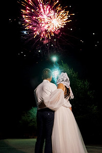 在夜空的背景上的轻夜火显示与新婚夫妇