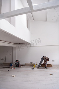 在新公寓的施工现场制作强化地板的熟练工人