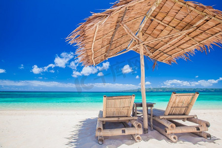 沙滩椅和伞在一个美丽的热带海滩，看法与复制空间。沙滩椅和雨伞