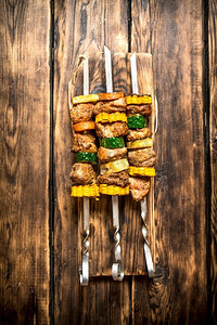 背景板红色背景摄影照片_把猪肉和蔬菜串放在串上。在木制背景上。把猪肉和蔬菜串放在串上。