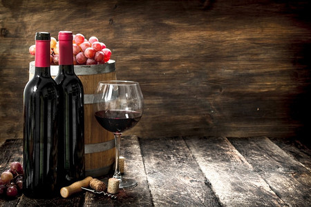 葡萄酒背景。一桶红酒和新鲜葡萄。在木制的背景上..葡萄酒背景。一桶红酒和新鲜葡萄。