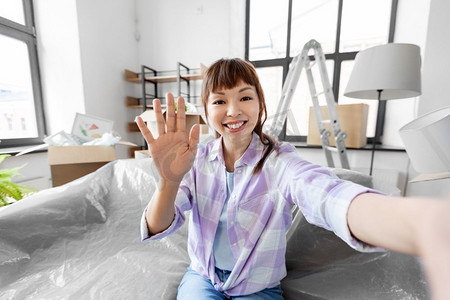 房地产视频框摄影照片_移动，人和房地产概念—愉快的微笑亚洲妇女采取自拍在新家。微笑的亚洲妇女采取自拍在新家