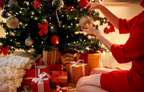 节日，庆祝和人的概念—妇女手装饰圣诞树与球。用球装饰圣诞树的手
