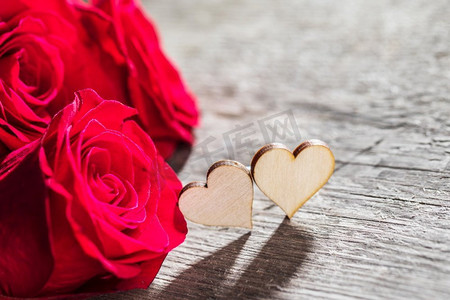 心和红玫瑰在木背景情人节设计。心和红玫瑰