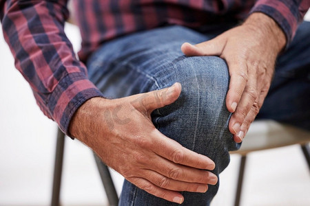 近拍成熟的男人遭受疼痛或关节炎紧握膝盖