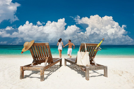 情侣在马尔代夫的热带海滩上跑步放松