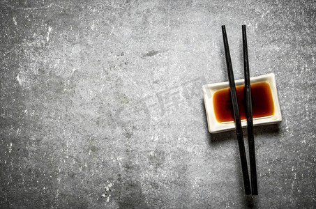 寿司用筷子蘸酱油。在石桌上。寿司用筷子蘸酱油。