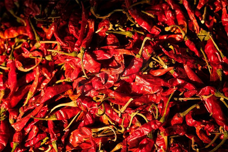 干燥的红色辛辣的辣椒堆在亚洲市场关闭纹理背景。印度拉贾斯坦邦焦特布尔萨达尔市场。红辣椒