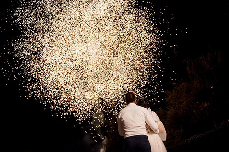 在夜空的背景上的轻夜火显示与新婚夫妇