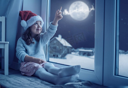 可爱的，小女孩看着月亮冬天的天空