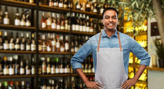 人，工作和职业概念—微笑的印度酒吧男招待或服务员围裙在葡萄酒酒吧背景微笑的印度酒保或服务员在葡萄酒酒吧