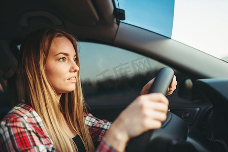 年轻的女初学者开车，后视镜。车里的女性，汽车司机的概念。年轻的女初学者开车，后视镜